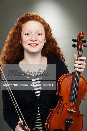 Portrait of mixed race teenage girl holding violin