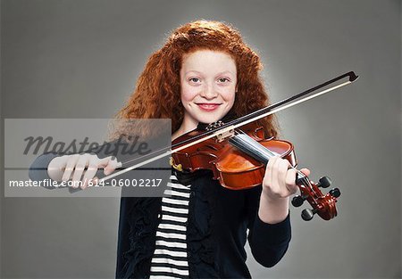 Portrait of mixed race teenage girl playing violin