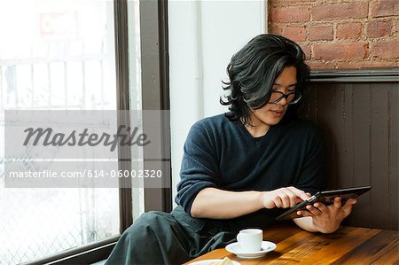 Young man using digital tablet in cafe