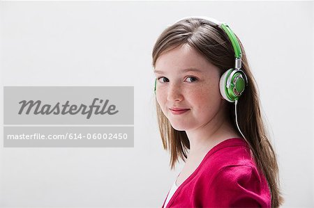 Girl in red wearing headphones, studio shot