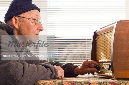 Senior man tuning radio, close up