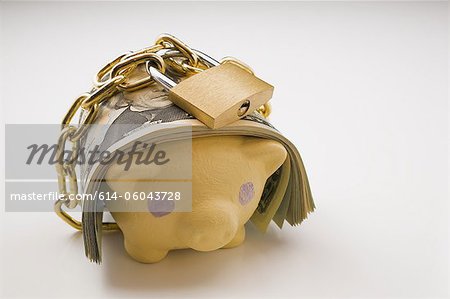 Piggy bank with bank notes and padlock