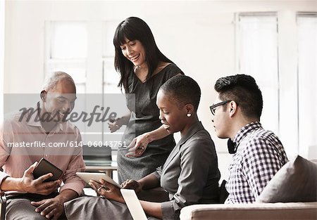 Businesspeople using digital tablets and handheld computers Businesspeople using digital tablets and handheld computers