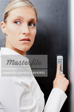 Woman pressing door keypad