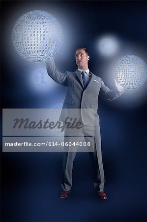 Businessman interacting with holographic binary globes