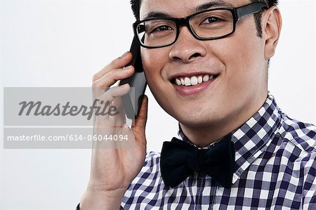 Young man using cellphone against white background