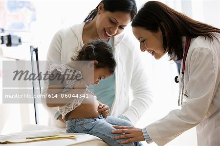 Doctor examing young girl in office