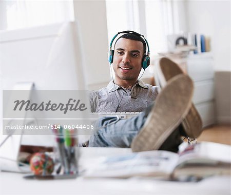 Young man relaxing at desk in office