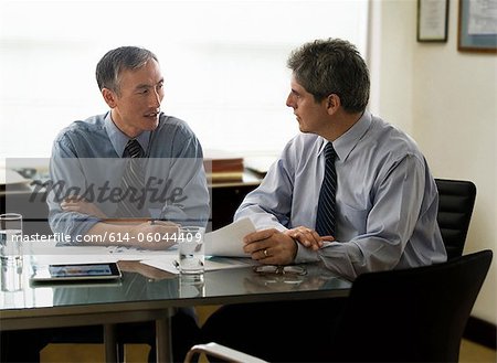 Businessmen discussing report in office