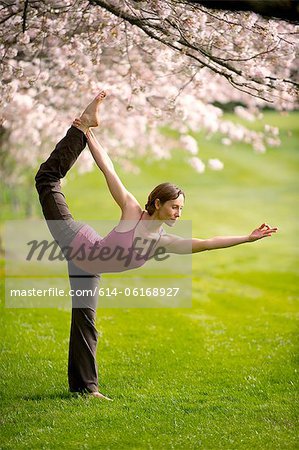 Woman in dancer yoga position in park