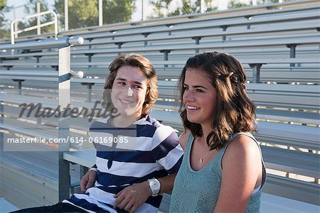 Teenage couple sitting on bleachers