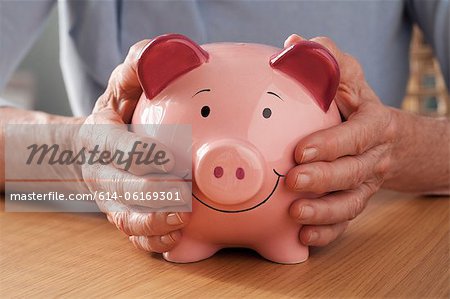 Senior woman holding piggy bank