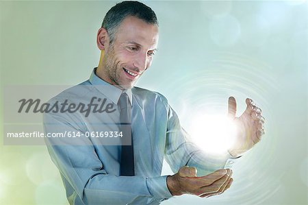Businessman holding ball of light