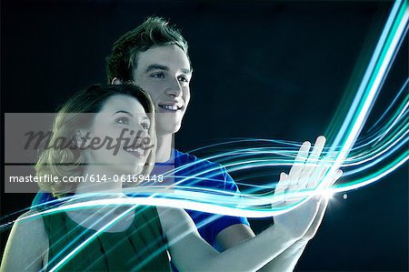 Young couple touching streams of light Young couple touching streams of light