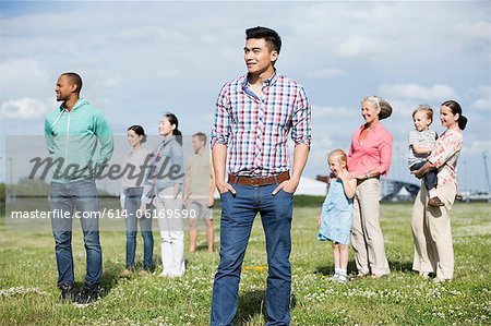 Young man standing in front of group of people outdoors