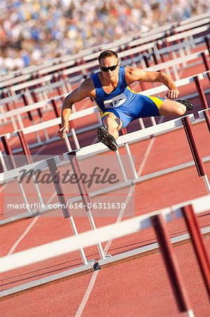 Male hurdler clearing hurdles