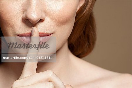 Woman with finger on lips, close up