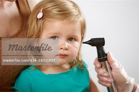 Little girl having her ear checked
