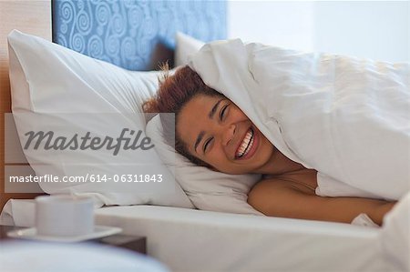 Happy young woman in bed