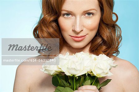 Woman holding roses, looking at camera