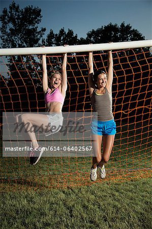 Girls hanging from soccer goal