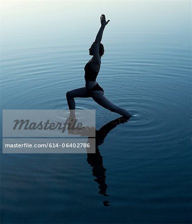 Woman in yoga pose in lake