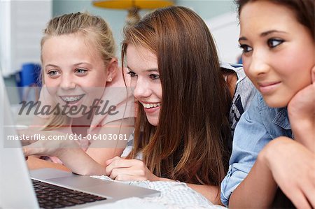 Teenage girls looking at laptop