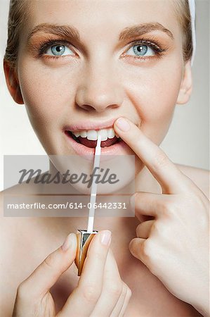 Woman using tooth whitening brush