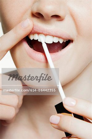 Woman using tooth whitening brush