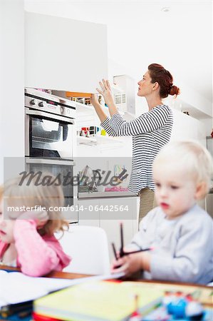 Mother opening kitchen cupboard