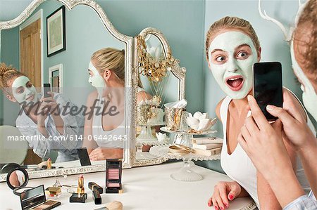 Woman wearing face mask being photographed by friend