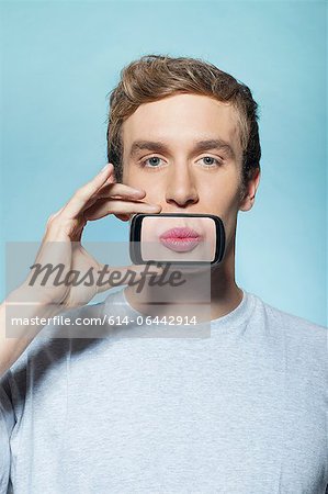 Man holding smartphone over mouth