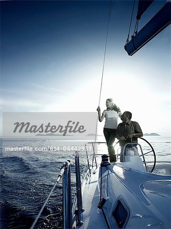 Couple steering a yacht Couple steering a yacht