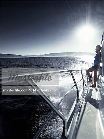 Woman standing alone on deck of yacht