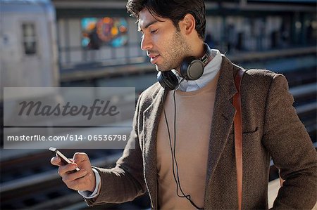 Man using cell phone at train station