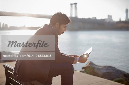 Man using tablet computer outdoors