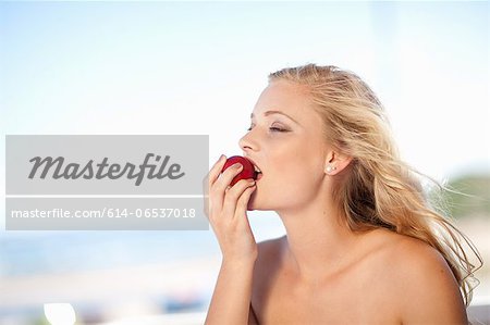 Woman eating apple outdoors