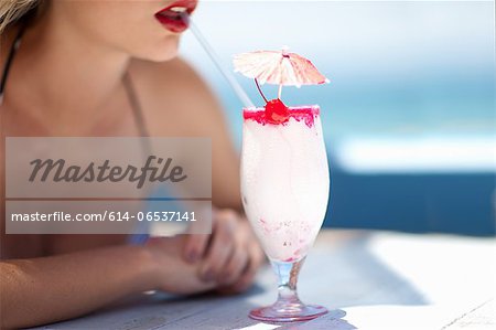 Woman having tropical drink outdoors