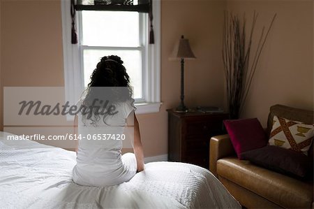 Woman sitting on edge of bed