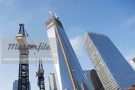 Low angle view of crane and skyscrapers