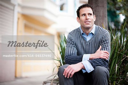 Businessman by tree on city street