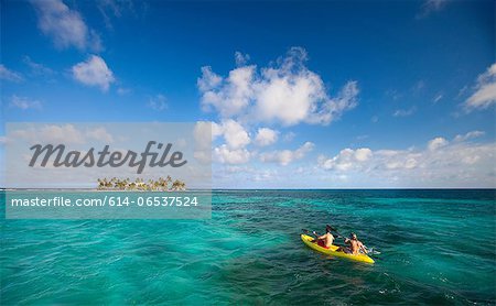 People rowing canoe in tropical water People rowing canoe in tropical water