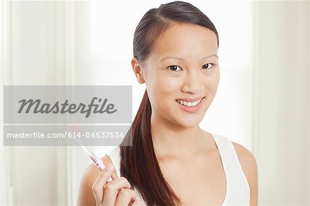 Woman holding toothbrush in bathroom