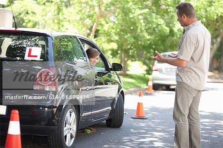 Father teaching teenage daughter driving