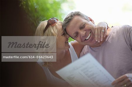 Smiling couple reading menu outdoors