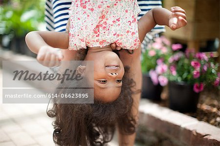 Mother holding daughter upside down