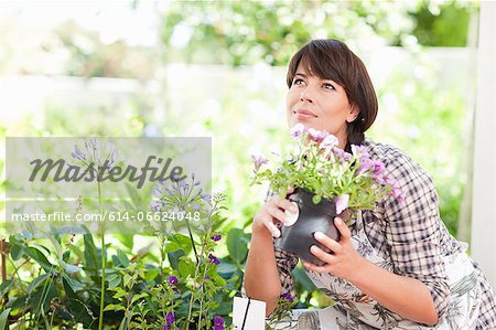 Woman with potted plant in garden