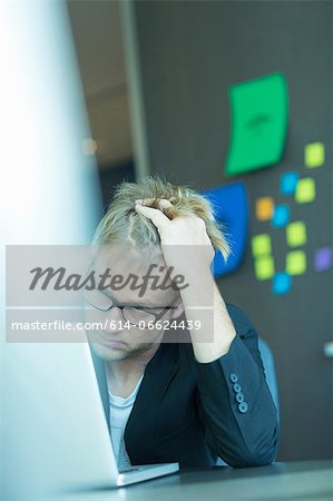 Frustrated businessman using laptop