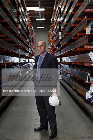 Businessman standing in metal plant