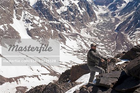 Hiker walking on rocky mountainside Hiker walking on rocky mountainside